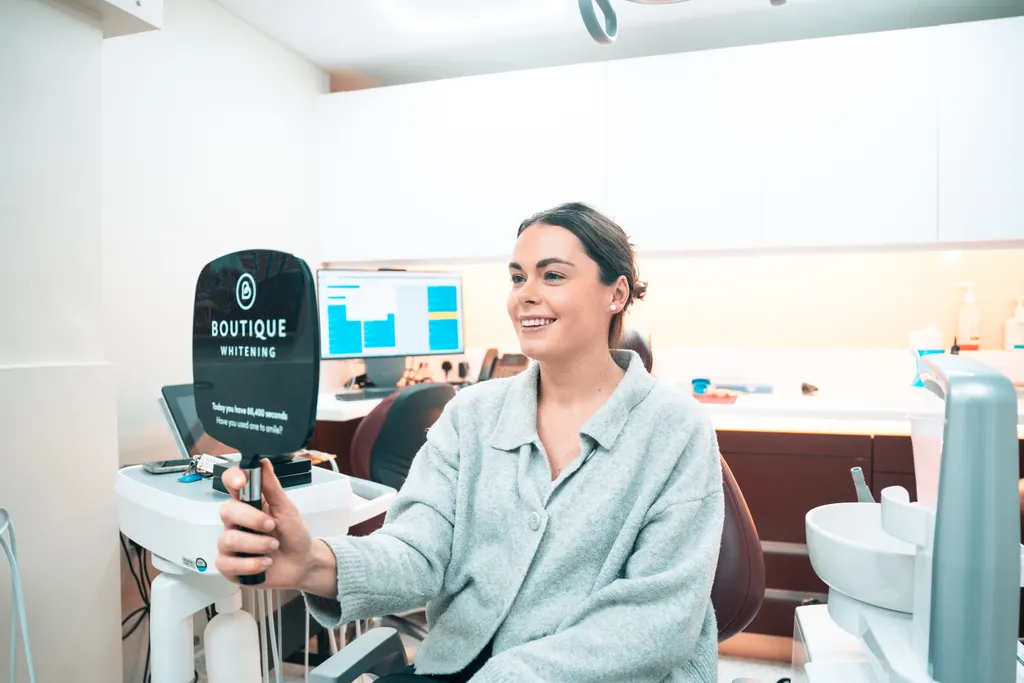 A smiling Pearly Whites patient in the treatment room
