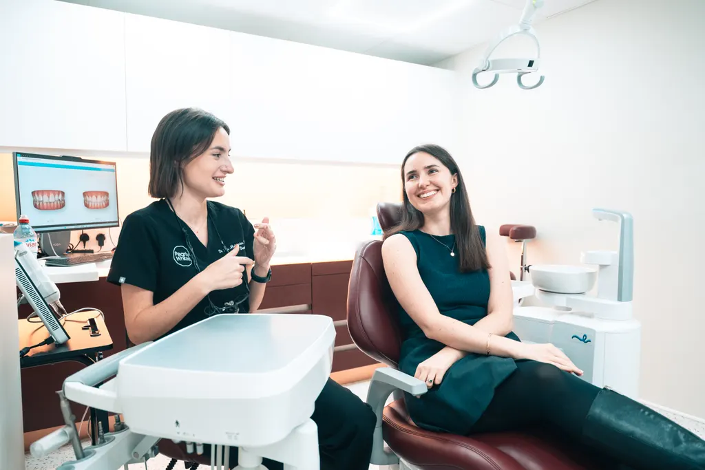 A Pearly Whites dentist chatting with a patient in the dental chair