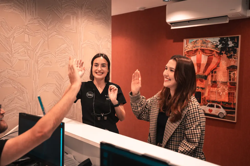 A patient sharing a high five with the team at reception