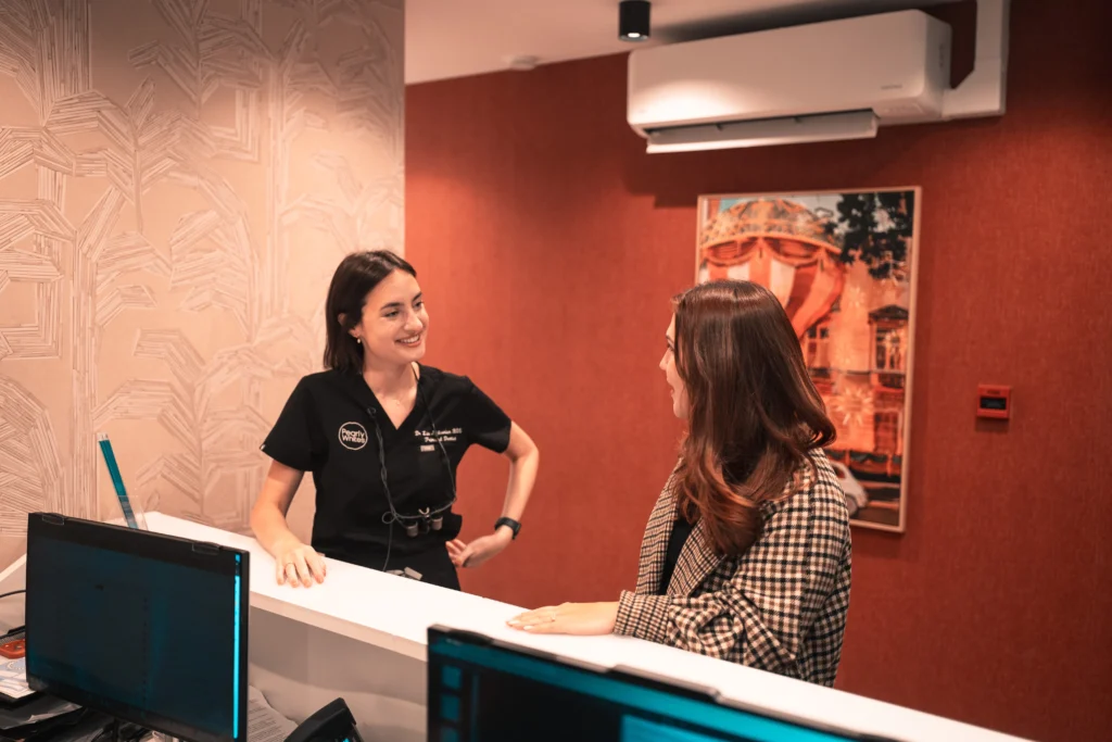 A patient being welcomed at the Pearly Whites reception desk