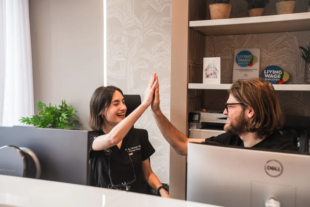 Dr Lia and Grant sharing a high five at reception